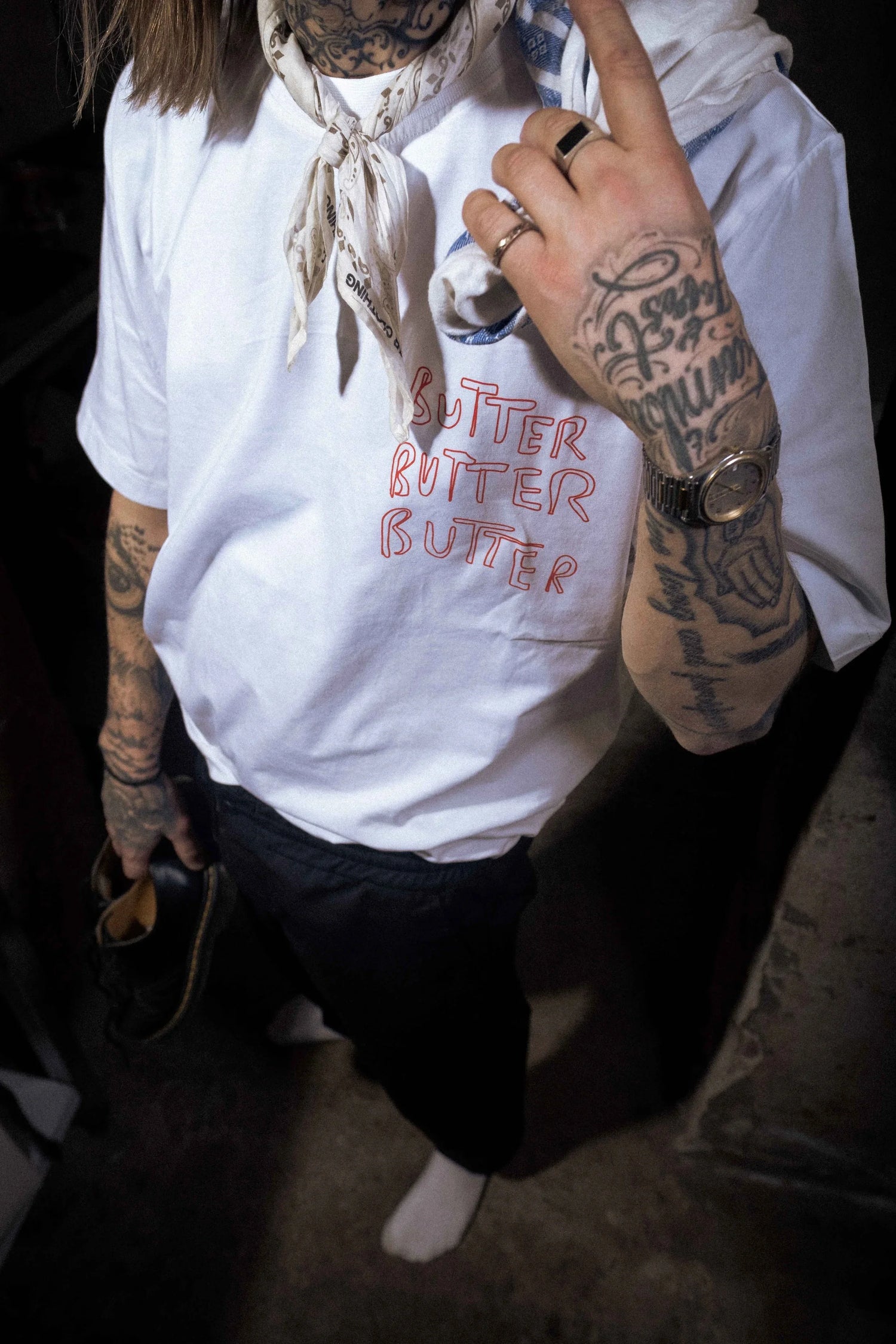 Kvinna med vit t-shirt med rött tryck "Butter Butter Butter"