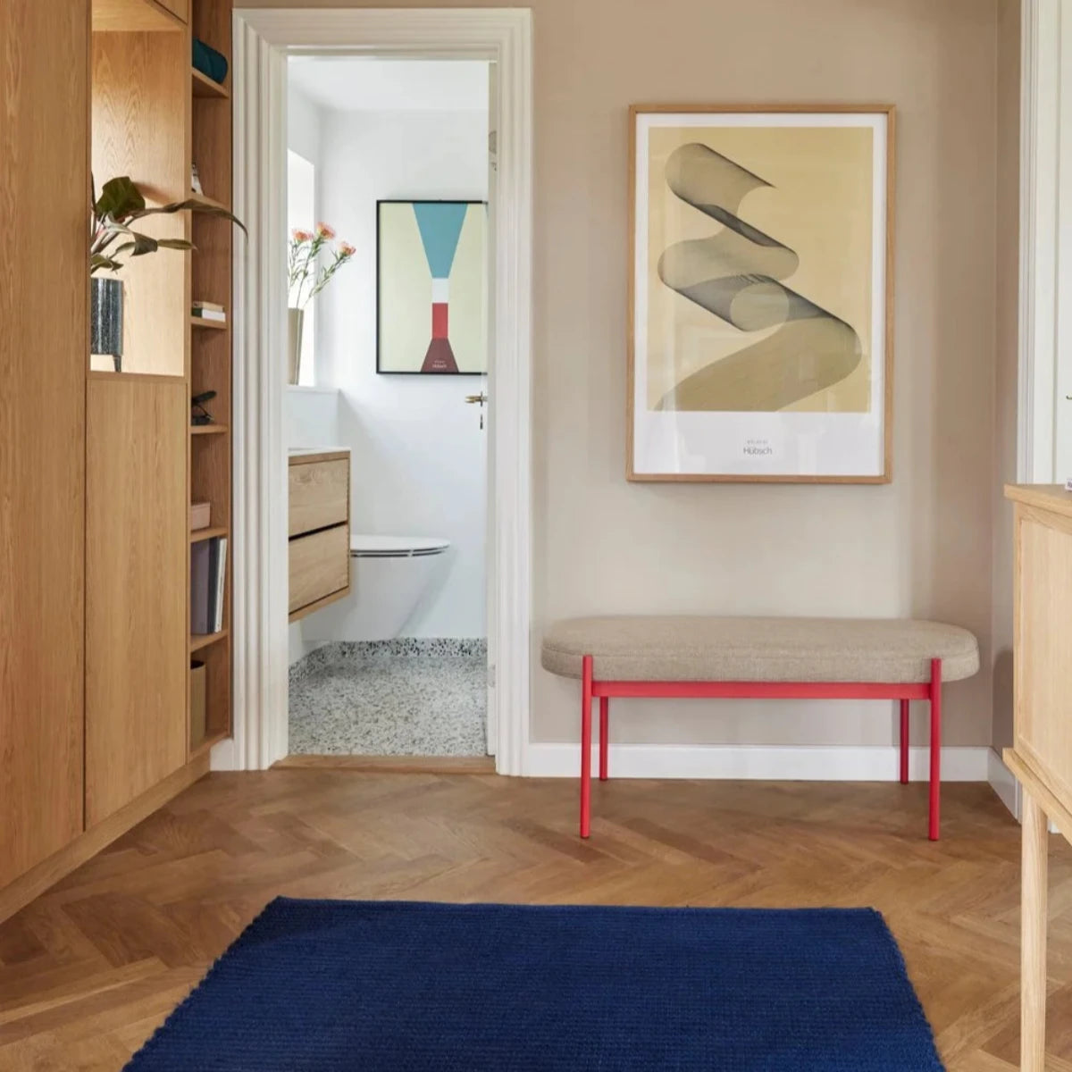 Röd bänk med dyna i rum med blå matta