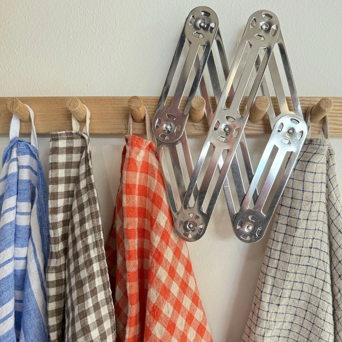 väggkrok med 4 kökshanddukar och grytunderlägg i rostfritt stål