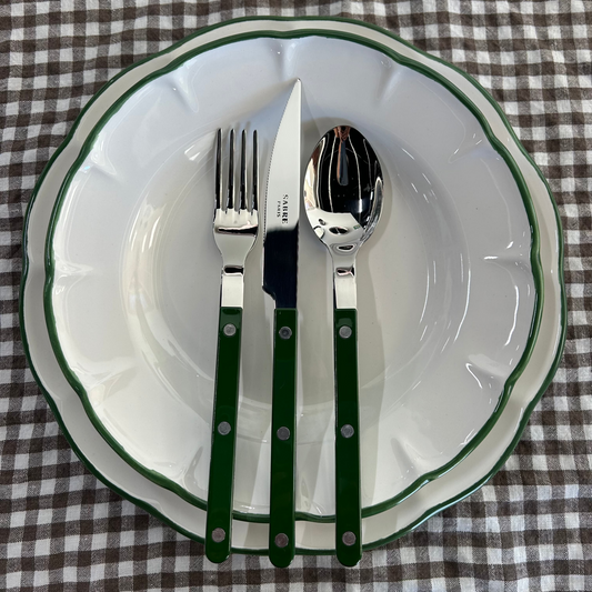 Dukning på brunrutig duk med porslin med grön kant och mörkgröna bistrobestick från Sabre Paris. Fotat på Mon Bistro & Friends