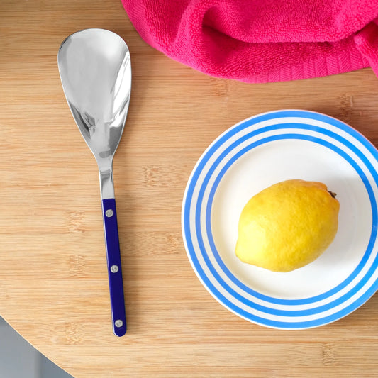 Serveringssked med mörkblått handtag på ett bord