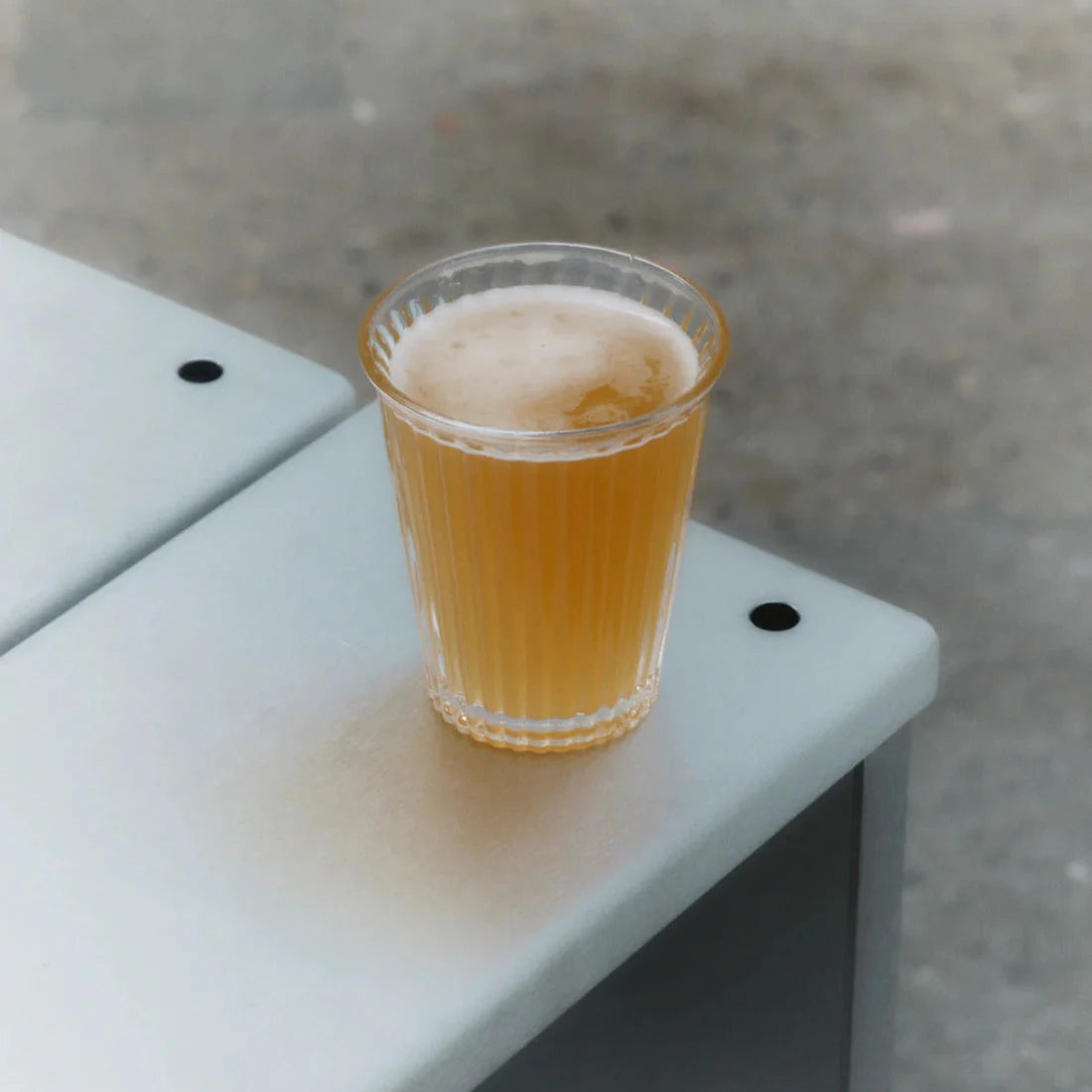 Service Projects glas med öl i ståendes på en bänk.