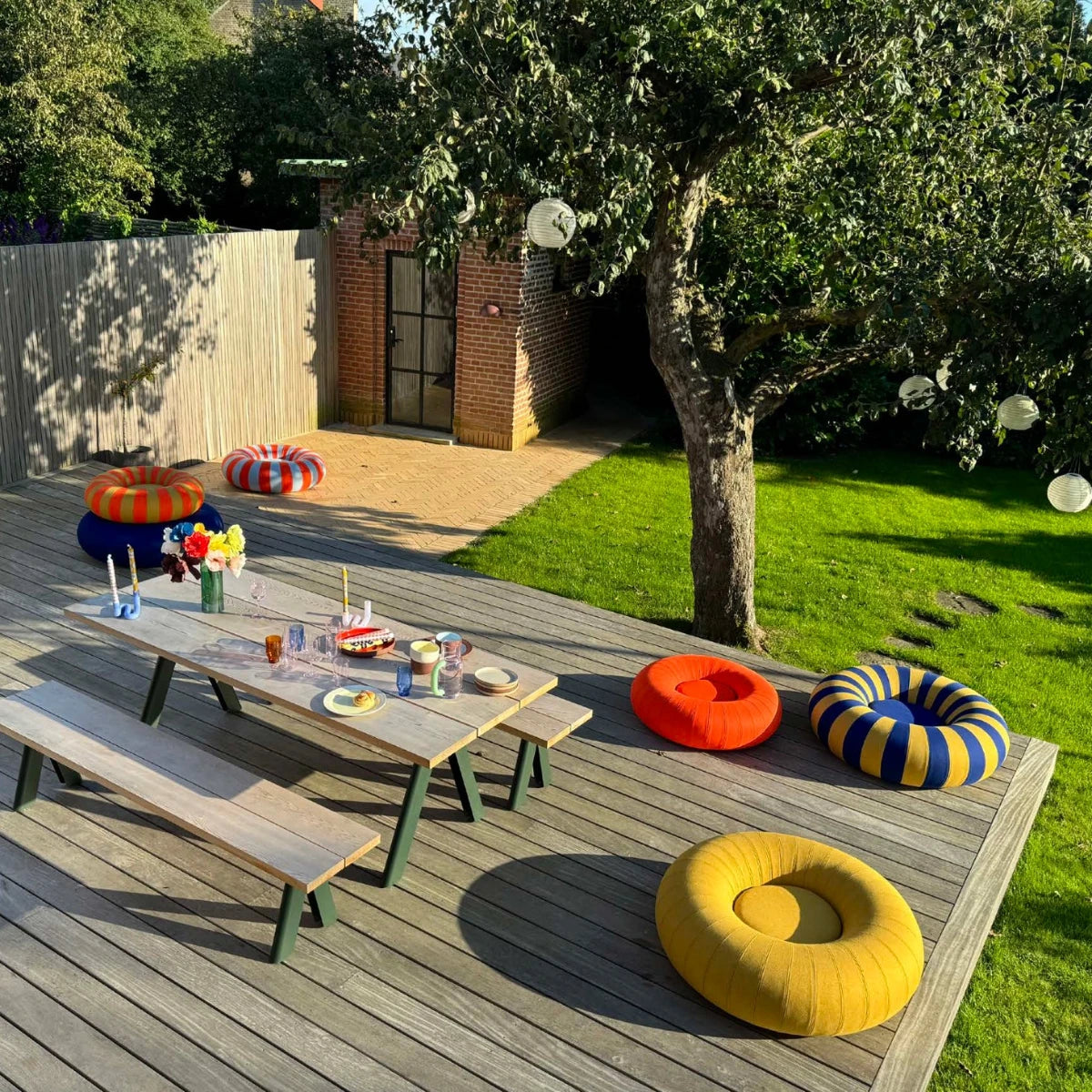 Studio about float puffar utspridda på ett trädäck med dukat bord