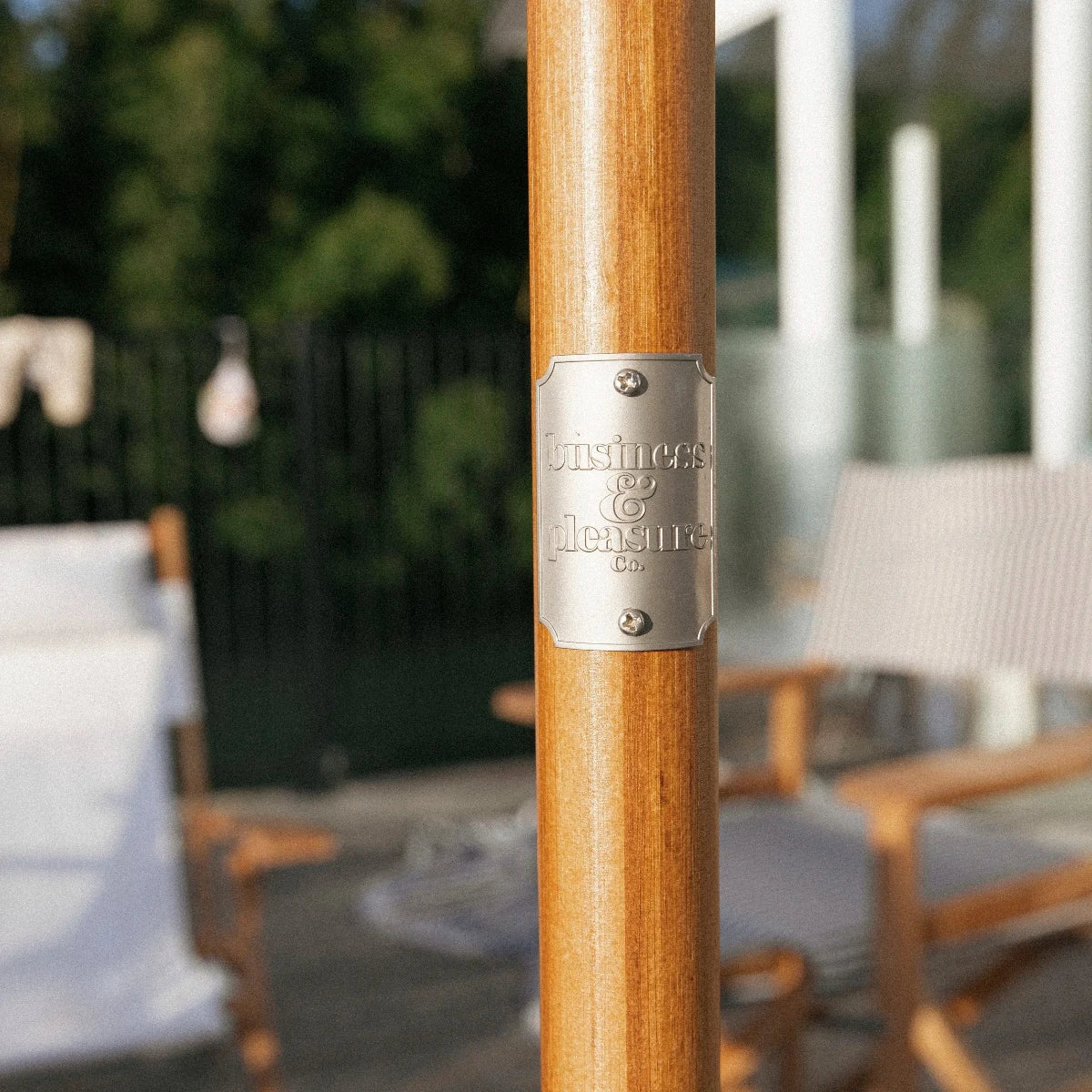 närbild på parasollpinne business and pleasure silvrig plakett med logotyp