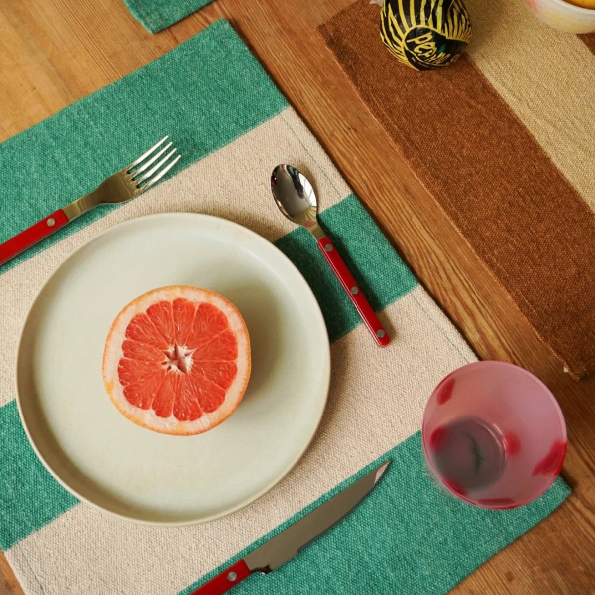 sabre bestick röda dukat på bord, en tallrik med skiva blodgrape