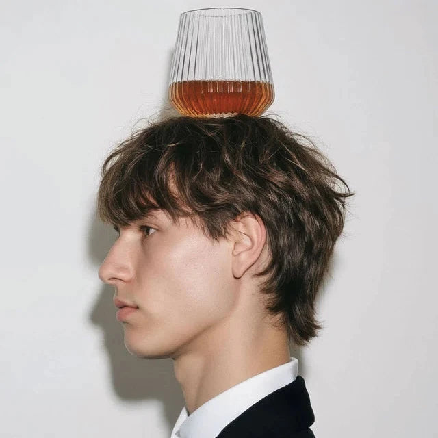 En man som har ett plastglas balanserandes på sitt huvud