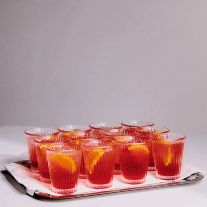 Canteen Bodega Glas från Service Projects på en silverbricka med massa glas på med orange dryck och en apelsinskiva i varje 