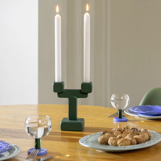 Dukat bord med ljusstake och glas med flerfärgad blå/grön fot från &Klevering. 