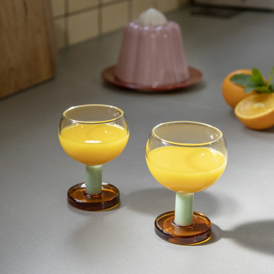Glas på fot med apelsinjuice i. 