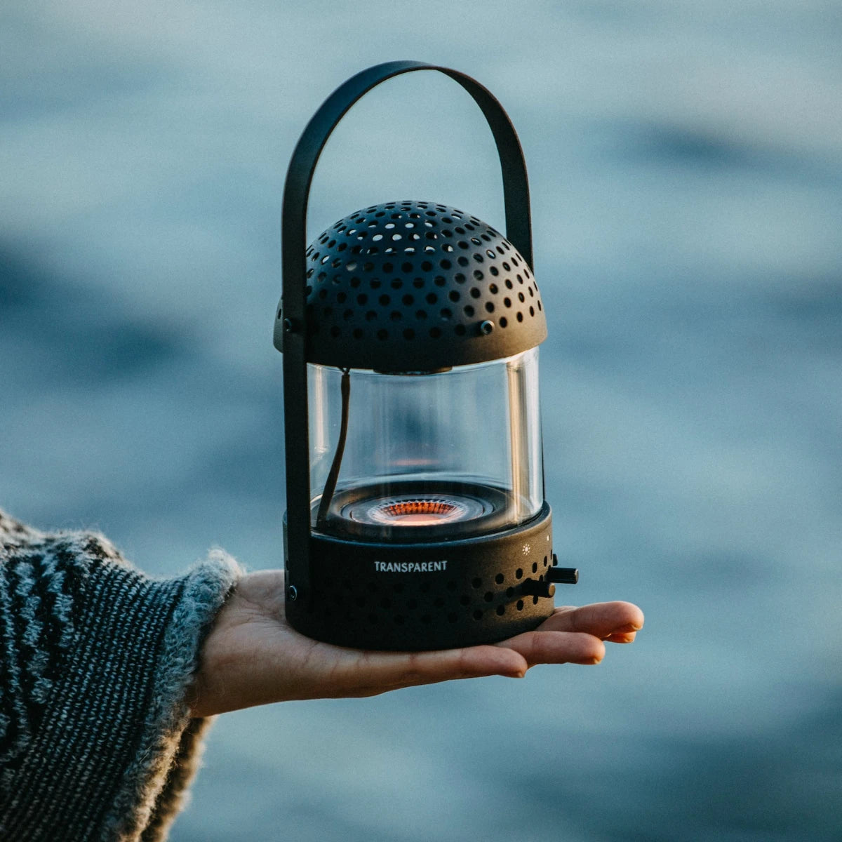 Transparent light speaker svart I öppen handflata utomhus