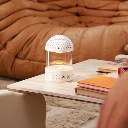 Transparent Light speaker på ett soffbord med en brun skinnsoffa i bakgrunden