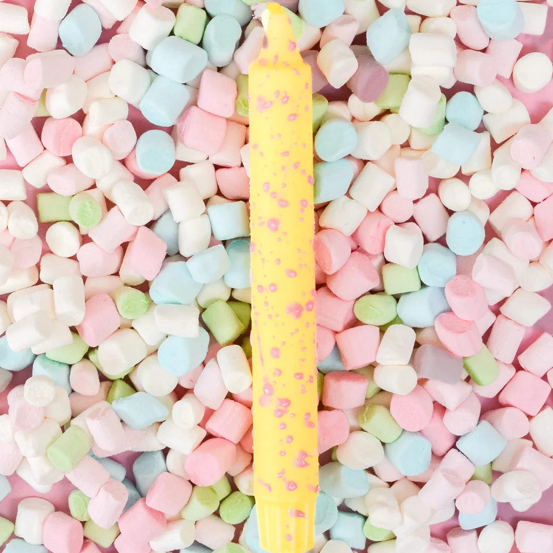 gult stearinljus med rosa konfetti 